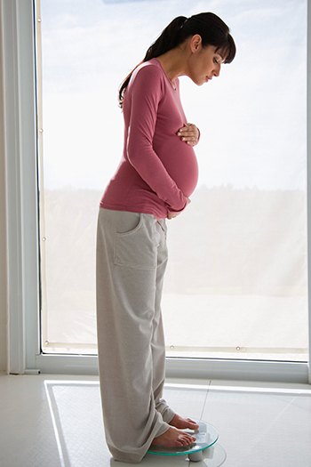 Pregnant Woman Standing on Scale